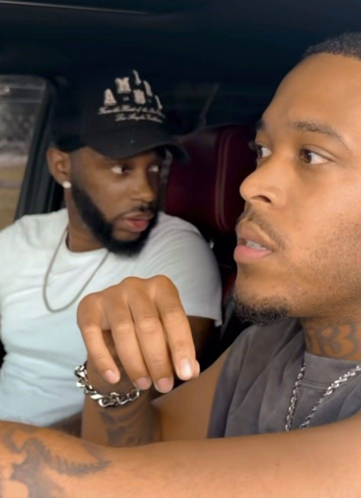Vertical short-form still: Jack Funny in the front seat of a car mid-conversation with a passenger behind him.